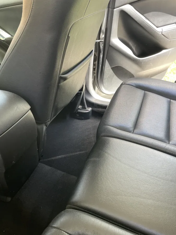 Wiped-down leather rear seat and floor after an interior detail
